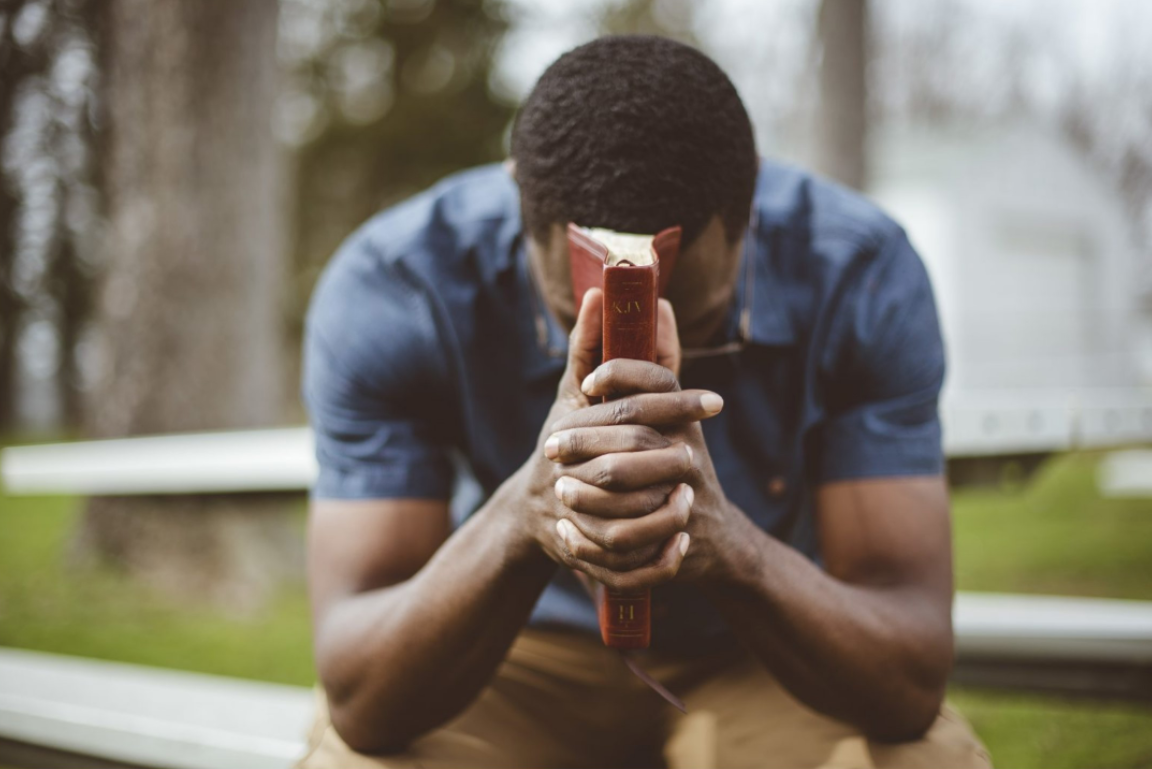 young man prays for strong faith in God